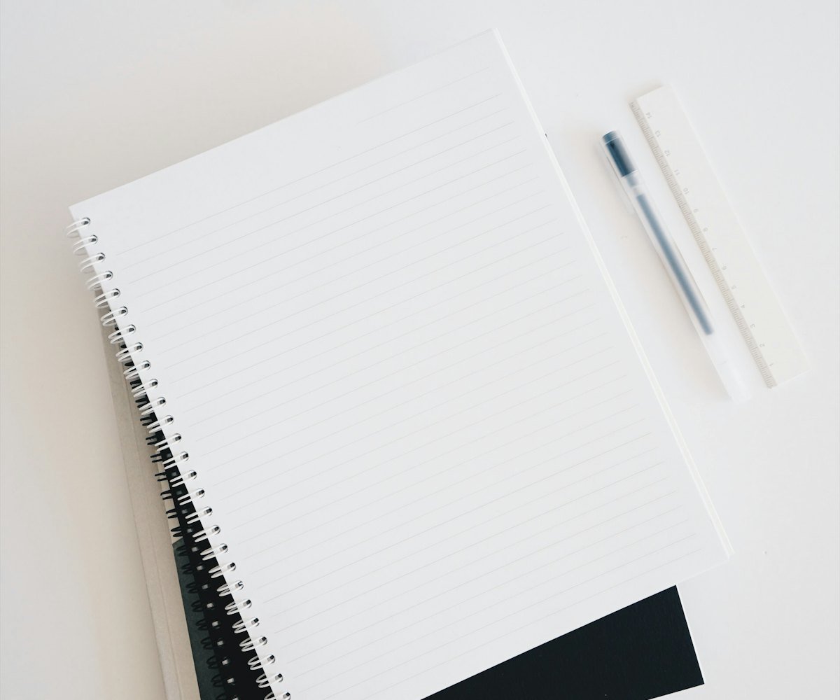 An open branded notebook and pen laid out on a desk