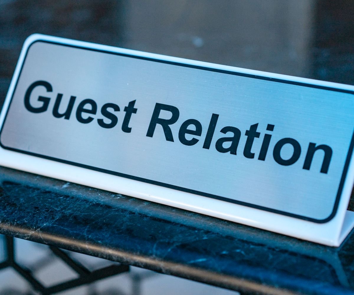 A brushed steel desk name plate on a reception counter