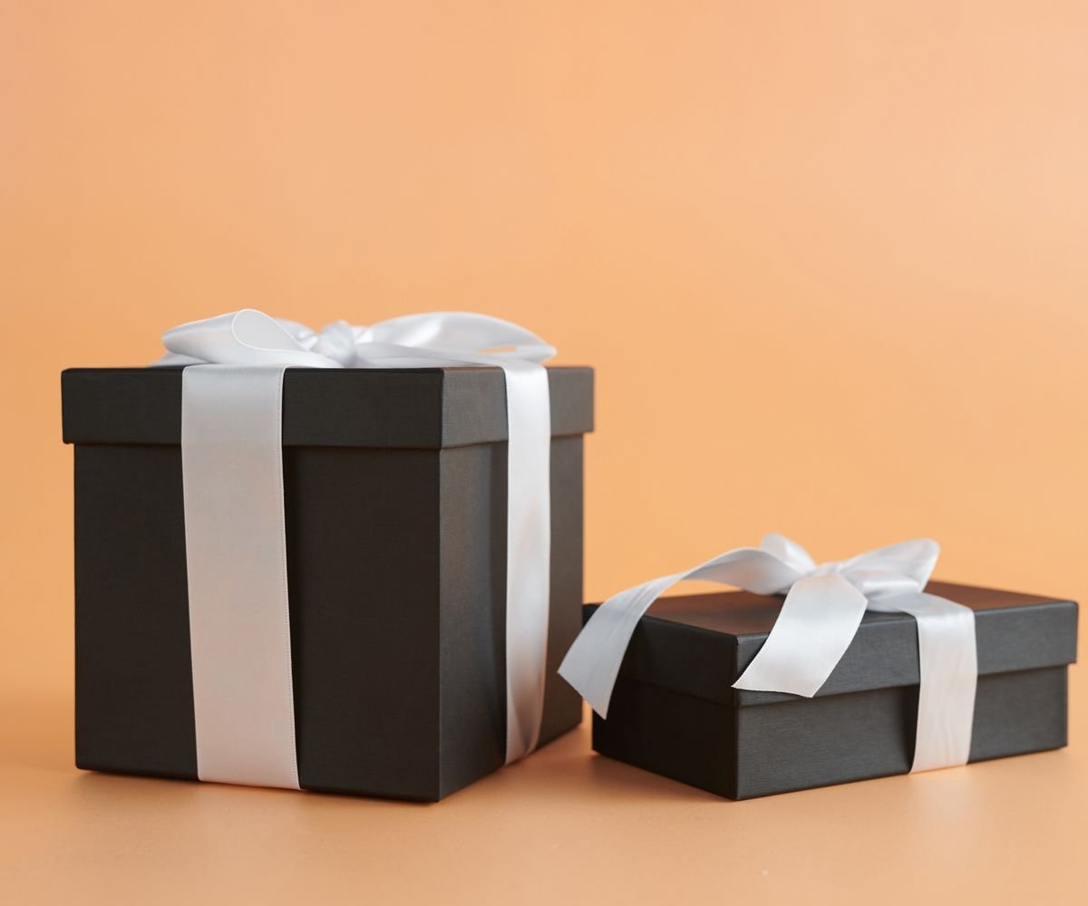 Two dark premium gift boxes finished with pale satin ribbon