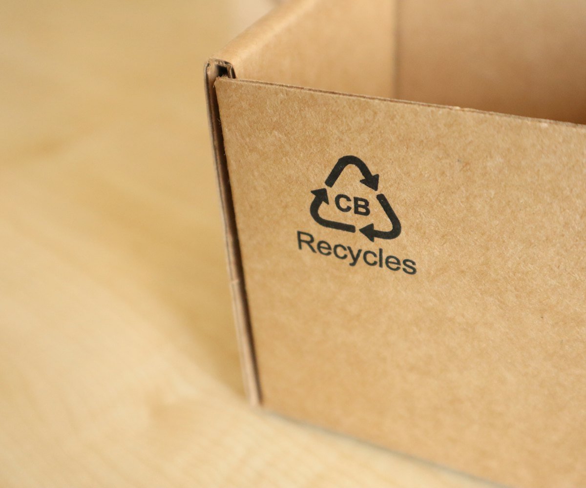A cardboard gift box printed with a recycling symbol